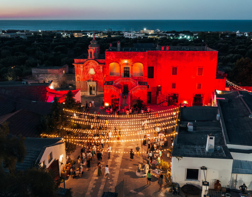 Festa paesana in Masseria, con luminarie e la facciata rossa della Masseria di sera